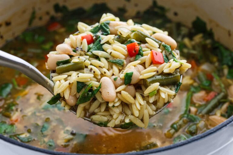 Soup being scooped out of bowl.