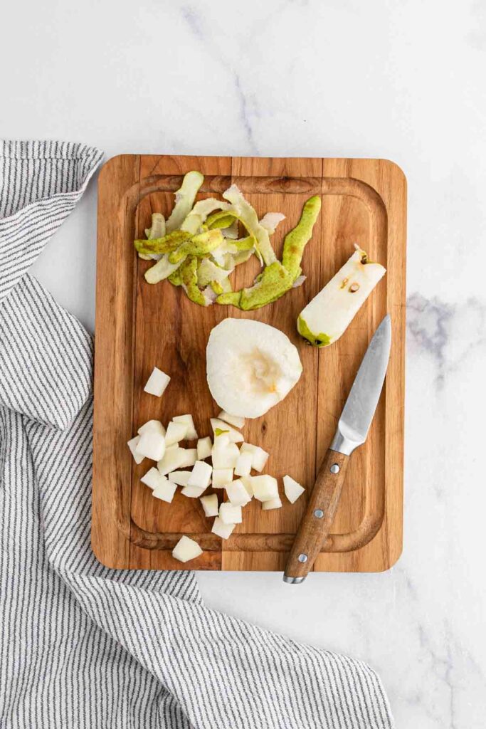 Peeled pair on cutting board. Shown being diced in to small pieces.