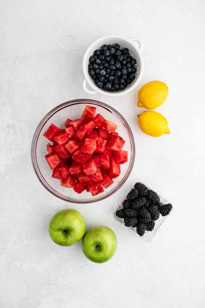 Ingredients for fruit salad: watermelon, blackberries, lemon, apples, blueberries