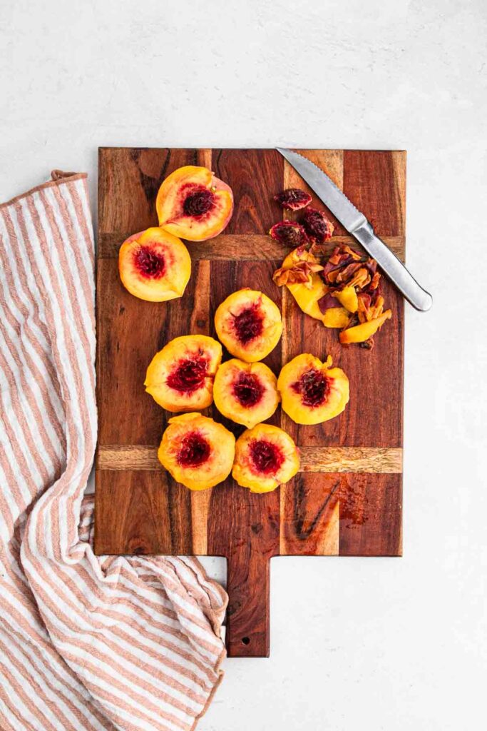 Peaches on cutting board being sliced.