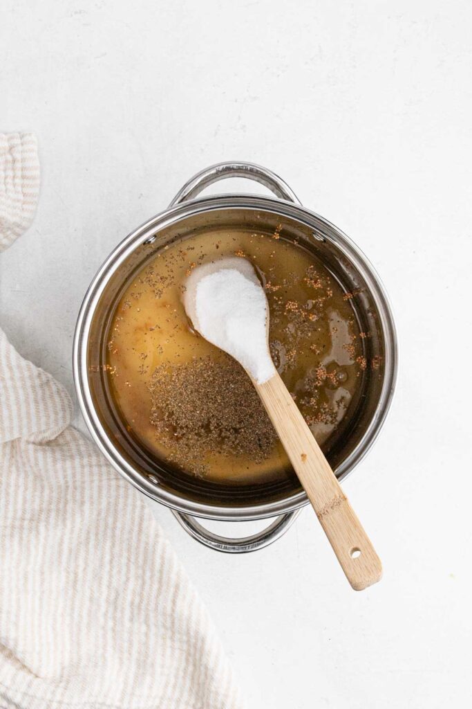Stirring brine in metal pot.